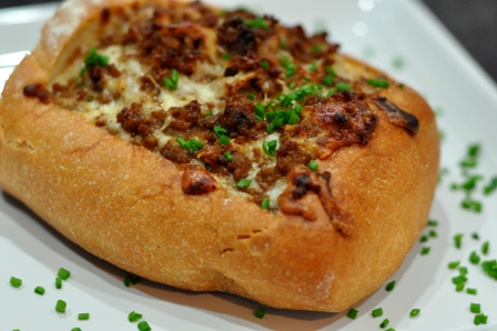 Bread stuffed with cheese and chorizo, garnized with chives