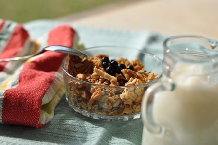 Granola with milk, spoon, and a brightly colored napkin