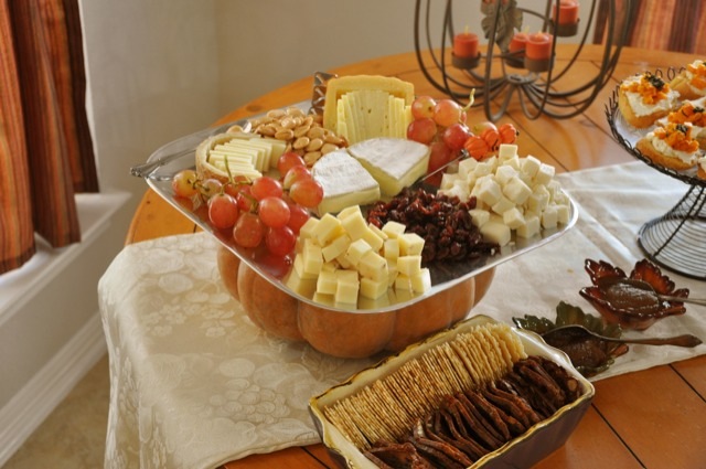 A pumpkin becomes as pedestal for a cheese plate at a fall party